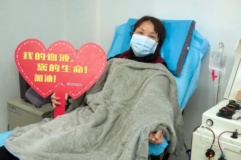 在武汉血液中心的中国医学科学院CPnCoV项目组，康复病人、来自汉口医院的护士蔡桃英在献血浆时拍照留念。她说同事们都在一线忙碌，她献血浆后，再休息几天就准备回到岗位上班，她说自己感染是由于早期防护不足经验不够造成的，再次回到工作岗位一定没有问题（2月17日摄）。新华社记者 才扬 摄