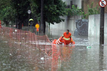A sanitation worker wades through a heavily flooded road in Sao Paulo, Brazil, Jan. 4, 2010. The continuous rainfall in recent days inundated many areas of the city. (Xinhua/AE)