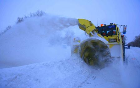 A machine cleans snow on the road of Habahe County in Aletai, northwest China's Xinjiang Uygur Autonomous Region, Jan. 6, 2010. A blizzard hit Aletai on Wednesday and would be expected to stop by Jan. 6 according to local weather apartment. The area has seen continuous blizzard and sharp temperature drop since December in 2009, which leads to serious disasters in agriculture and livestock breeding.(Xinhua/Liu Xinhai)