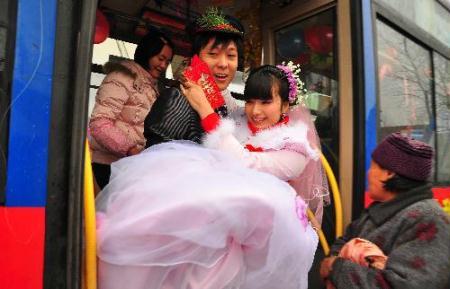 Groom&nbsp;Deng&nbsp;Hui&nbsp;kisses&nbsp;his&nbsp;bride's&nbsp;hand&nbsp;at&nbsp;a&nbsp;bus&nbsp;they&nbsp;chose&nbsp;as&nbsp;their&nbsp;wedding&nbsp;limousine&nbsp;in&nbsp;Sanhe&nbsp;Town&nbsp;of&nbsp;Fuyang&nbsp;City,&nbsp;east&nbsp;China's&nbsp;Anhui&nbsp;Province,&nbsp;on&nbsp;Feb.&nbsp;9,&nbsp;2010.&nbsp;(Xinhua/Lu&nbsp;Qijian)