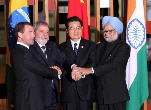 Chinese President Hu Jintao (2nd R), Brazilian President Luiz Inacio Lula da Silva (2nd L), Russian President Dmitry Medvedev (1st L) and Indian Prime Minister Manmohan Singh (1st R) shake hands during a group photo session at the second summit meeting of BRIC (Brazil, Russia, India and China) leaders in Brasilia, capital of Brazil, April 15, 2010. (Xinhua/Liu Weibing)