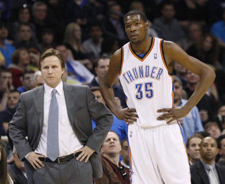 Oklahoma City Thunder head coach Scott Brooks (L) and guard Kevin Durant (35) watch from the bench as a San Antonio Spurs player shoots free throws in the first half during their NBA basketball game in Oklahoma City, Oklahoma, March 22, 2010.[Photo/Agencies]