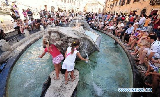 Tourists cool off around the famous Fountain of the Old Boat in downtown ... Tourists cool off around the famous Fountain of the Old Boat in downtown ...