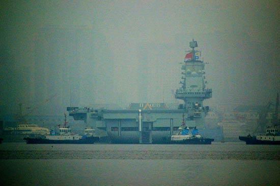 China's first aircraft carrier, the Liaoning, anchored for the first time in a military port in Qingdao, eastern Shandong province on Wednesday morning.