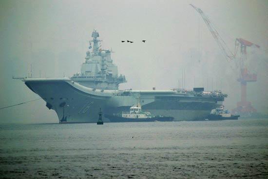 China's first aircraft carrier, the Liaoning, anchored for the first time in a military port in Qingdao, eastern Shandong province on Wednesday morning.