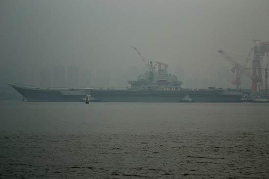 China's first aircraft carrier, the Liaoning, anchored for the first time in a military port in Qingdao, eastern Shandong province on Wednesday morning.