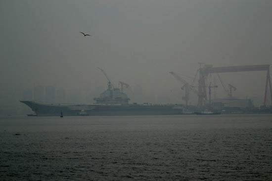 China's first aircraft carrier, the Liaoning, anchored for the first time in a military port in Qingdao, eastern Shandong province on Wednesday morning.