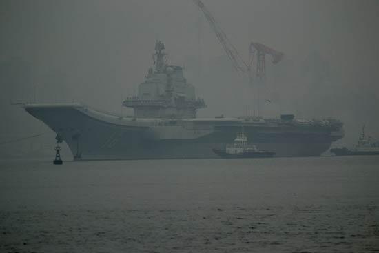 China's first aircraft carrier, the Liaoning, anchored for the first time in a military port in Qingdao, eastern Shandong province on Wednesday morning.
