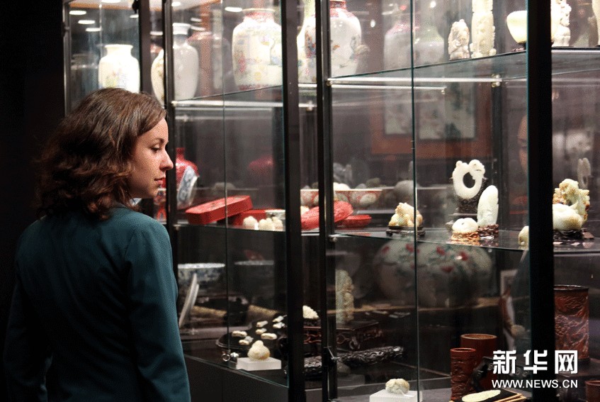 10月6日，一位外国观众在博览会上驻足欣赏玉雕展品。