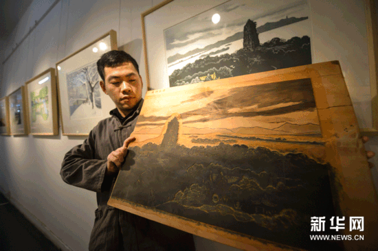 （4）12月18日，工作人员在展示反映西湖“雷峰夕照”景色的水印木刻作品《晚钟远逝》以及木刻版。