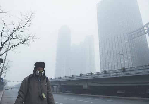 图片说明：29日，一名行人戴面具在北京的雾霾天气中出行。