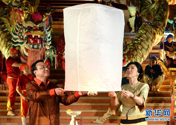 10月12日晚，中国国务院总理李克强在泰国清迈与泰国总理英拉身穿民族服装，共同放飞“孔明灯”，为中泰友好祝福。 新华社记者 刘建生 摄