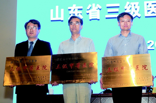 　　济宁市第一人民医院院长靳清汉（左一）领取三甲医院牌匾
