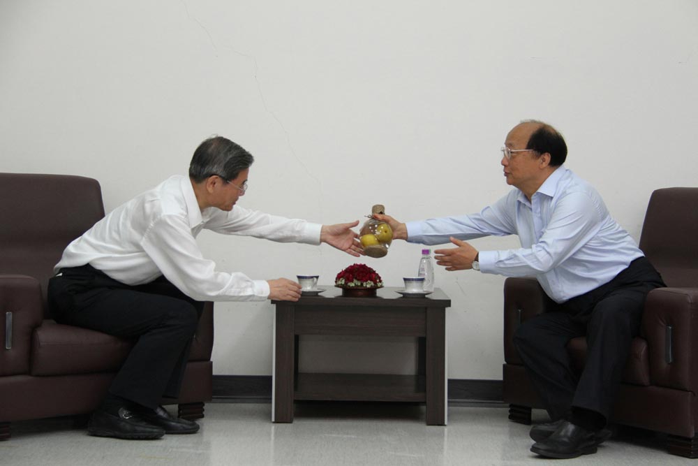张志军（左）28日参访台中市，台中市长胡志强（右）致赠“瓶中梨”梨子酒