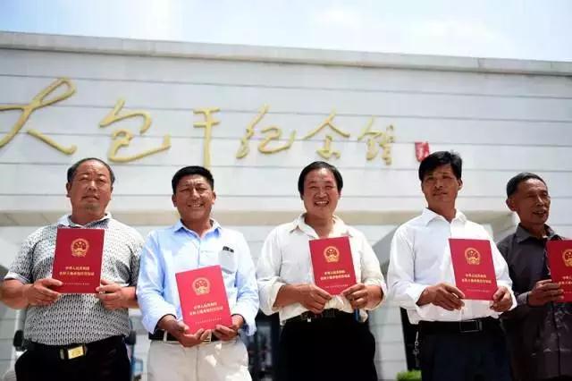 安徽凤阳县小岗村农民展示领到的《农村土地承包经营权证》（2015年7月8日摄）。新华社记者 刘军喜 摄