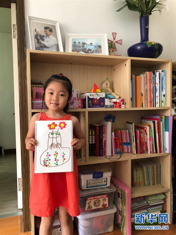 在沈阳市沈河区大南街道多福社区，丛龙江的孙女丛婧涵在展示自己的画作（7月20日摄）。 新华社记者 于也童 摄