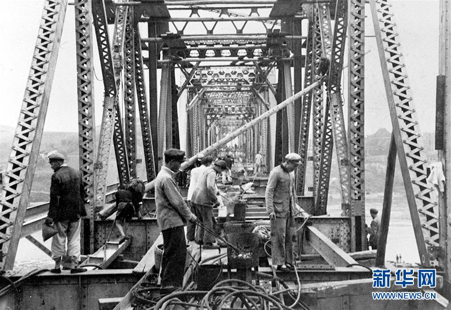 修建成渝铁路的工人们在紧张地架设沱江大桥（资料照片）。 新华社发