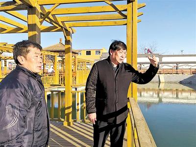李文武（右）计划明年在郦道元公园水面种植荷花，既可改善水质，还可以形成景观。记者 寇国莹摄