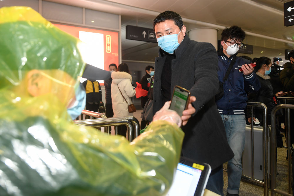 在杭州东站，从贵州乘坐外地复工人员专列抵达杭州的复工人员出站时经过红外测温仪（2月16日摄）。 新华社记者 黄宗治 摄