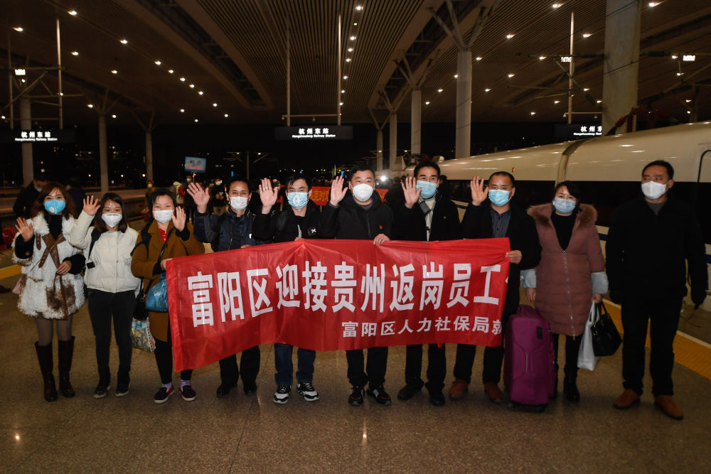 在杭州东站，从贵州乘坐外地复工人员专列抵达杭州的复工人员与杭州市富阳区的接车人员合影留念（2月16日摄）。 新华社记者 黄宗治 摄