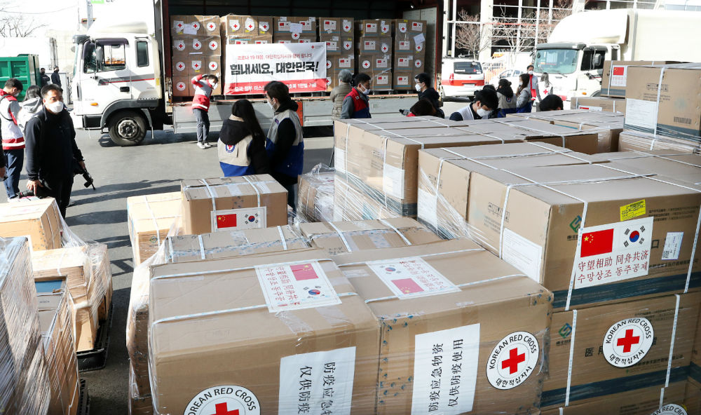 3月20日，在韩国仁川，大韩红十字社工作人员将中方援助物资搬上卡车。新华社/纽西斯通讯社