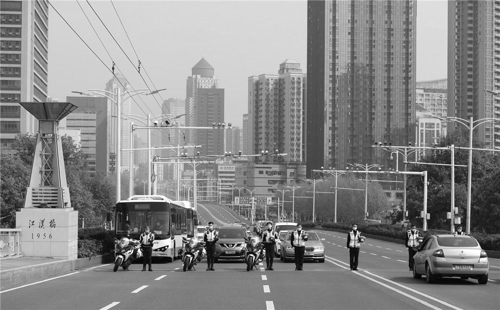 4月4日，在武汉市江汉一桥，武汉市公安局硚口区交通大队交警和市民停车鸣笛默哀。新华社记者 沈伯韩 摄