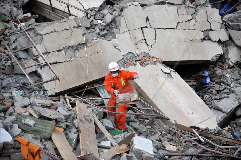 2010年4月15日，一名消防战士在玉树县结古镇的地震废墟中搜寻幸存者。新华社记者　聂建江摄