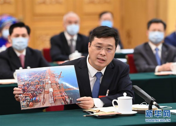 5月23日，全国人大代表韦韬在参加广西代表团审议时展示钦州港的照片。