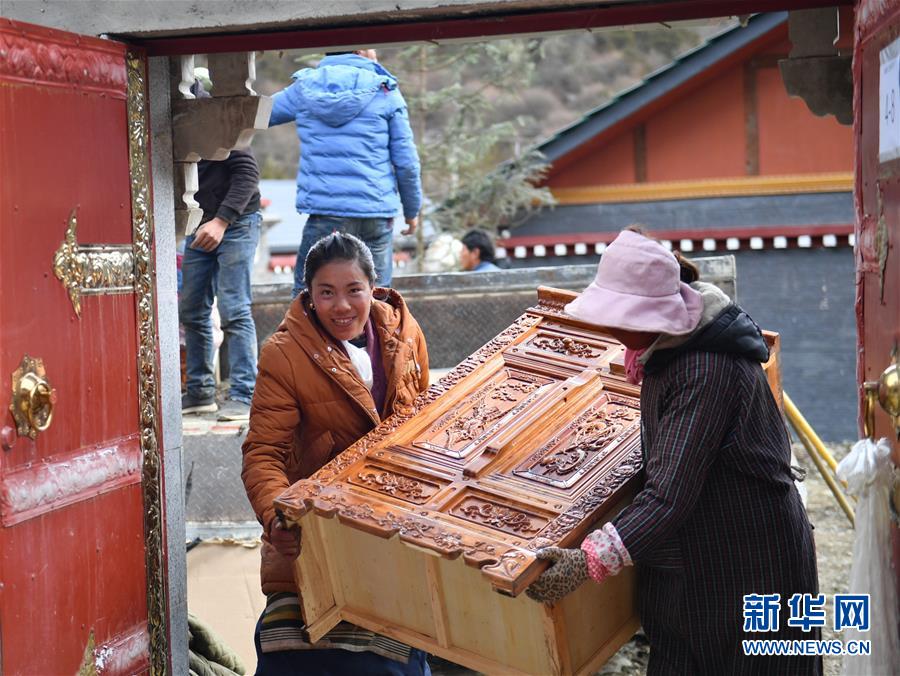 新搬入隆子县玉麦乡的居民在往新家搬藏式柜子（2019年4月8日摄）。