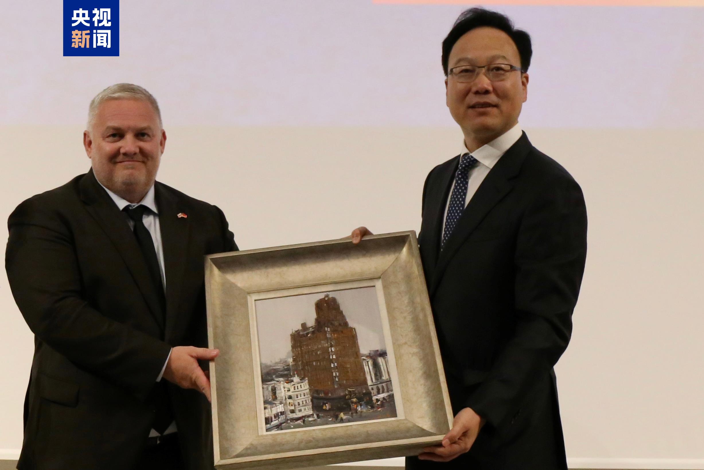 中央新聞紀錄電影製片廠（集團）董事長姚永暉（右）向斯洛伐克共和國文化部國務秘書馬魯什卡贈送油畫作品《向最高處去》