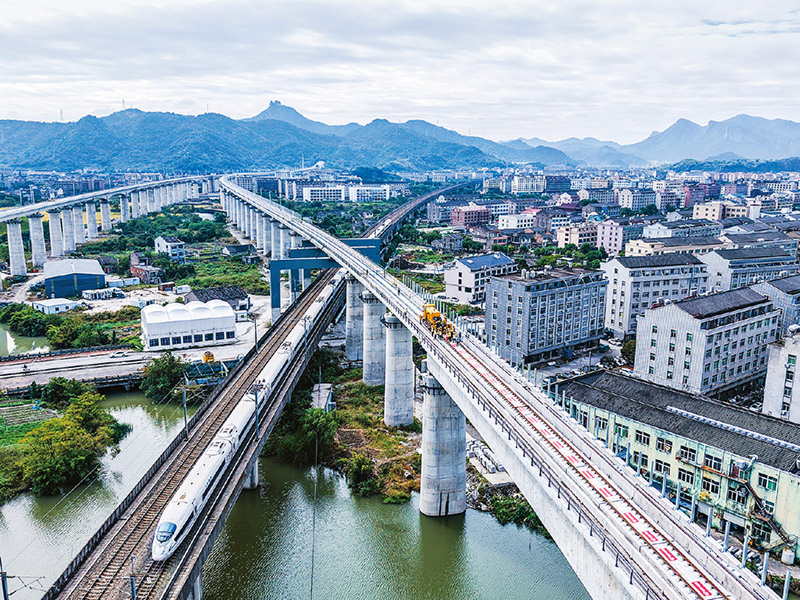 杭台高铁温玉段桥隧比高达90.34%,需穿越13座总长约18公里的隧道、跨越17座总长约16公里的桥梁。项目建成运营后将填补玉环市铁路空白,形成台州“县县通铁路、铁路网全覆盖”的交通格局。图为2025年11月5日,在杭台高铁温玉段施工作业现场,中铁十四局工作人员操作长轨牵引车进行铺轨作业。