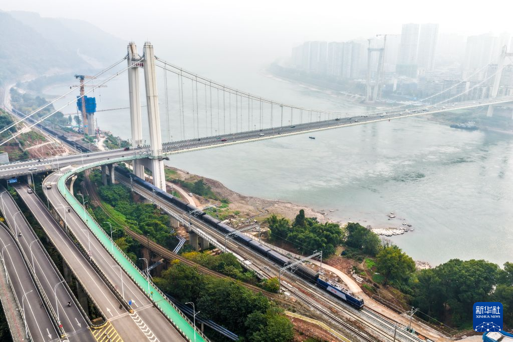 2025年12月11日,列车在成渝铁路扩能改造工程黄磏至铜罐驿站区间通行(无人机照片)。