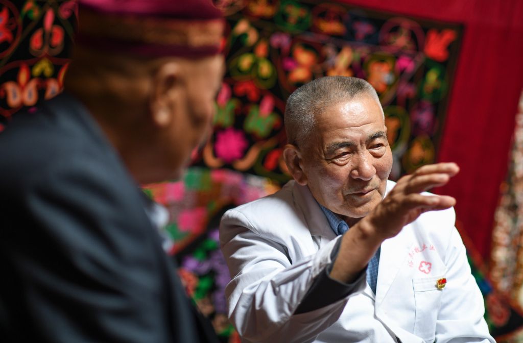 在新疆裕民县吉也克镇的巴尔鲁克山夏牧场,吾哈斯·苏来曼和牧民交流(6月17日摄)。