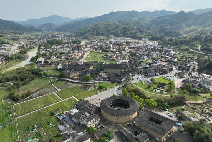 2026年4月9日,游客在福建省漳州市南靖县梅林镇参观怀远楼、和贵楼、长教溪等景点(无人机照片)。