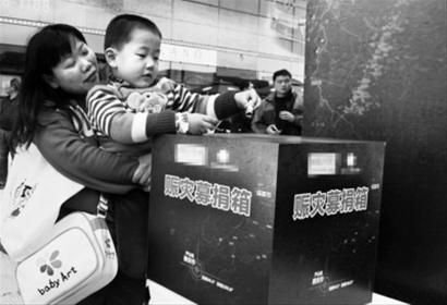 4月22日，一名儿童在家长的带领下为灾区捐款。 新华社