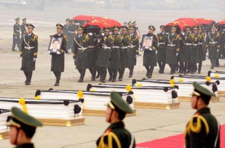Soldiers carry the coffins of the eight peacekeeping police officers who died in the Haiti earthquake at the airport in Beijing, China, Jan. 19, 2010. (Xinhua/Zhang Duo)