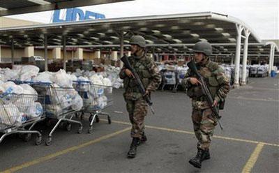 Soldiers walks past bags containing aid to be distribute among earthquake victims at a supermarket in Concepcion , Chile, Wednesday, March 3, 2010. (AP Photo/Natacha Pisarenko)