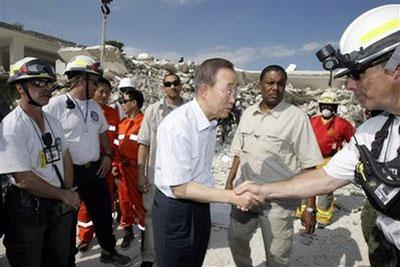 U.N. Secretary-General Ban Ki-moon, left, greets rescue workers at the destroyed U.N. headquarters in Port-au-Prince, Sunday, Jan. 17, 2010. (AP Photo/Francois Mori)