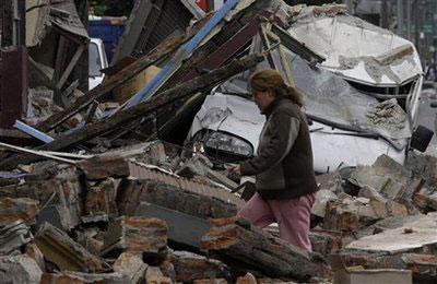 A woman walks among debris on a destroyed street in Talcahuano, Chile, Sunday, Feb. 28, 2010. (AP Photo/ Aliosha Marquez)