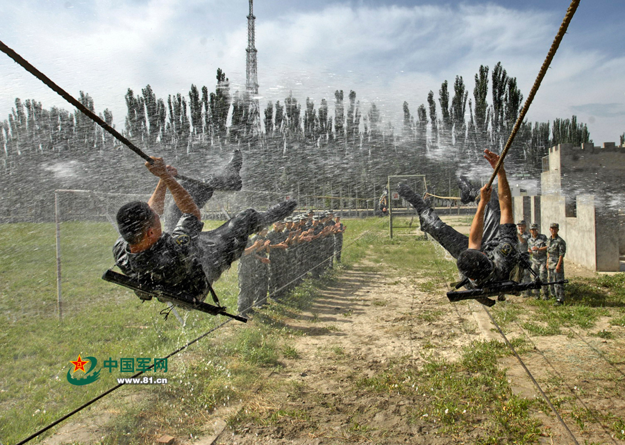 高清:解放军官兵炼战斗意志 水枪喷射下爬绳索