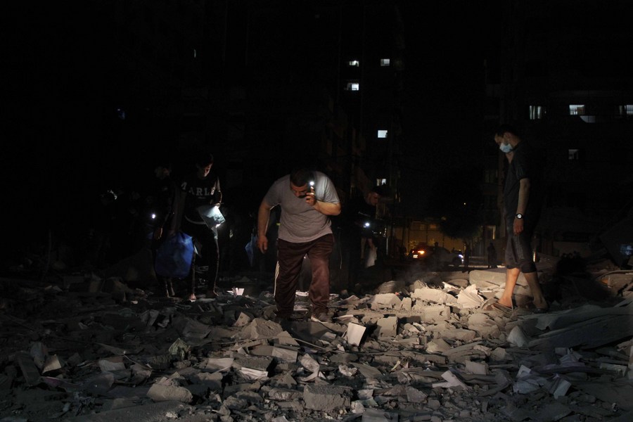 Palestinians inspect the rubble of a 12-storey tower destroyed by Israeli airstrikes in Gaza City, on May 11, 2021.