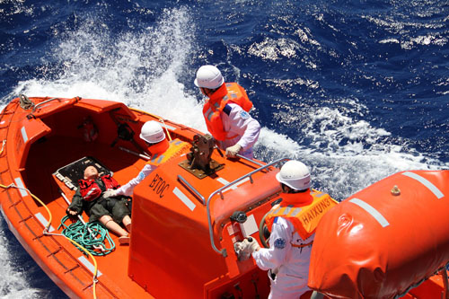 发现落水"船员"后,舰载直升机立即释放信号弹,并向海面抛出救生阀.