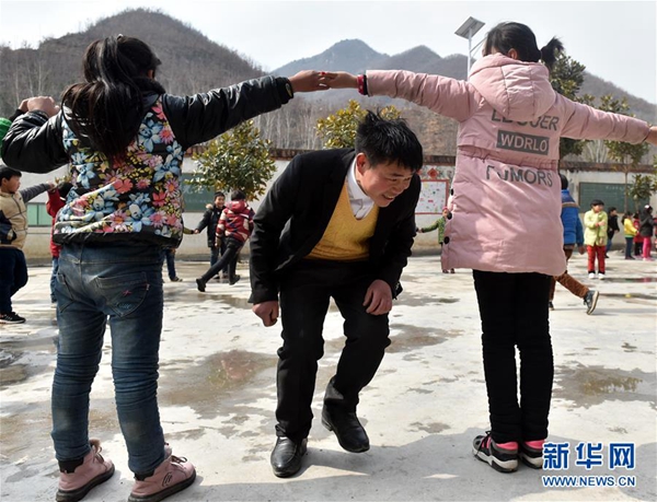 张玉滚在课间与学生们做游戏（3月20日摄）。新华社记者 李嘉南 摄