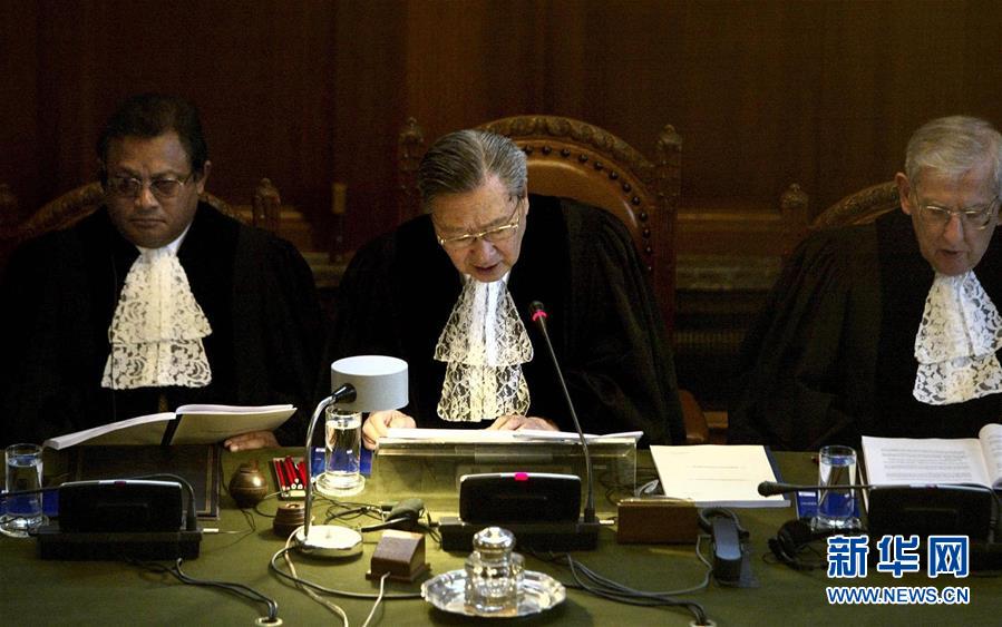 2004年7月9日，国际法院院长史久镛大法官（中）在荷兰海牙宣读法院裁定书。