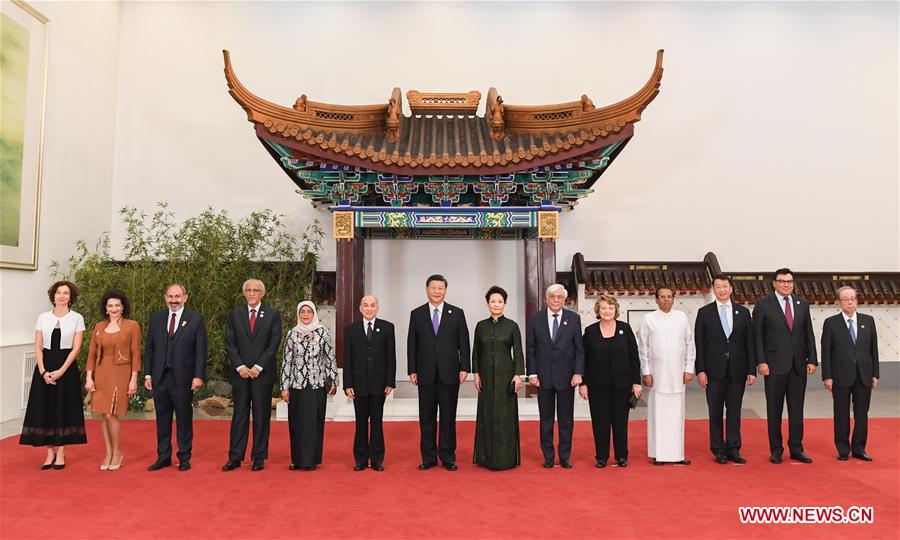 Chinese President Xi Jinping (7th L) and his wife Peng Liyuan (8th L) pose for group photos with guests who are in Beijing to attend the Conference on Dialogue of Asian Civilizations (CDAC), on May 14, 2019. Xi and his wife Peng Liyuan hosted a banquet in Beijing on Tuesday evening in honor of the guests. (Xinhua/Rao Aimin)