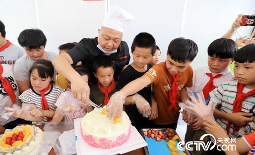 5月27日，在广西柳州市融安县长安镇泗朗村小学，学生们在学习和体验制作蛋糕。（谭凯兴 摄）