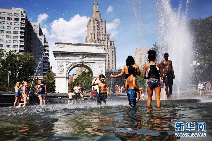 7月20日，在美国纽约，人们在喷泉中戏水降温。 新华社记者 李木子 摄