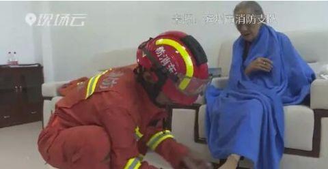 9旬老人被困水中，消防员救出后还帮她换上干净袜子