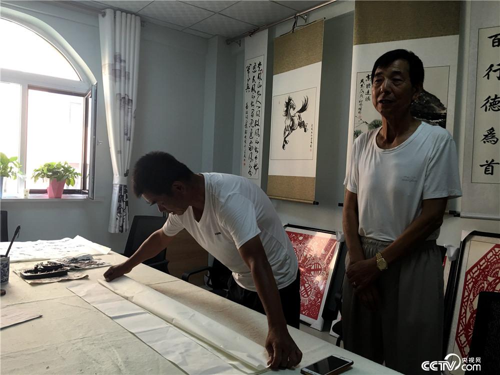 薛芳来（右）跟书法老师李俊明（左）学习书法