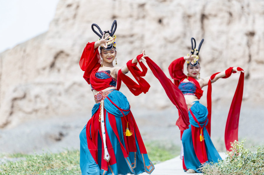 Dancers hold a live broadcast while performing local folk dances at cultural heritage sites in Kucha of Aksu Prefecture, northwest China